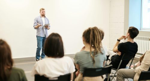 a man speaking in front of the whole class